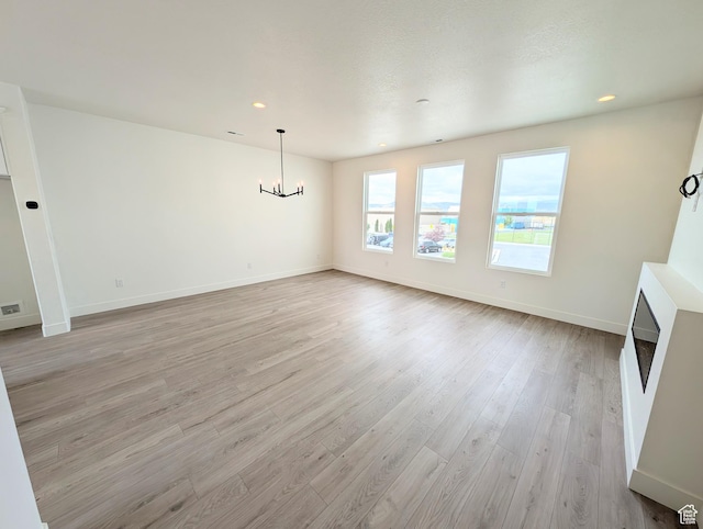 10634 S Cardinal Park Rd W Unit 148, South Jordan, UT 84009 - unfurnished living room with light wood-style flooring, a chandelier, and recessed lighting