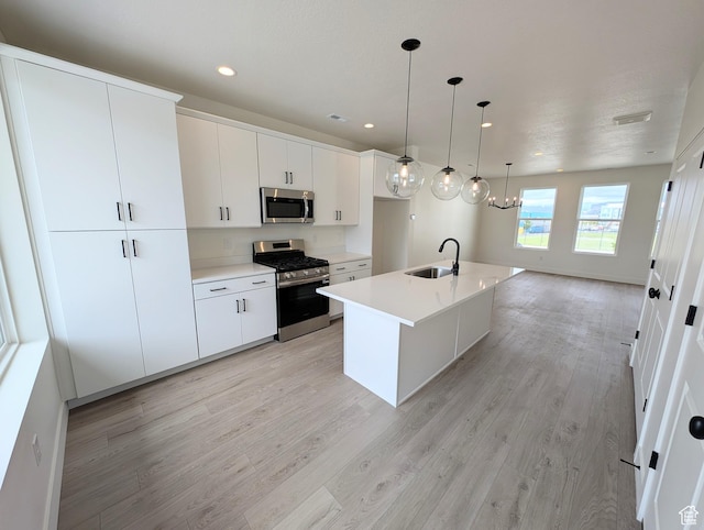 10634 S Cardinal Park Rd W Unit 148, South Jordan, UT 84009 - kitchen with stainless steel appliances, light wood-type flooring, light countertops, a center island with sink, and recessed lighting