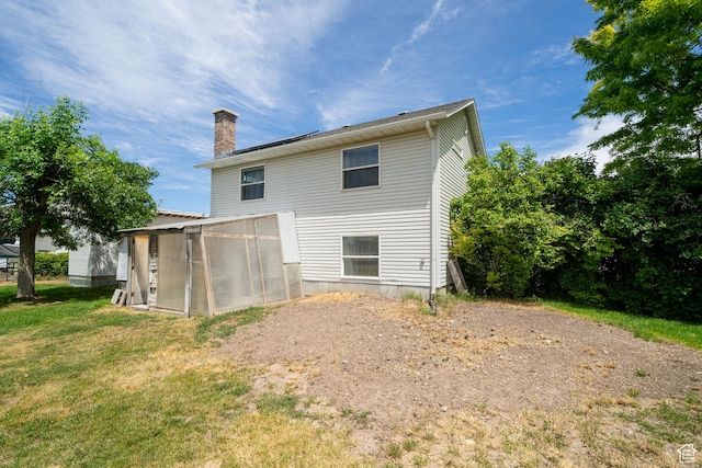 2891 S 600 W, Nibley, UT 84321 - back of house featuring a greenhouse, a chimney, a lawn, and an outbuilding