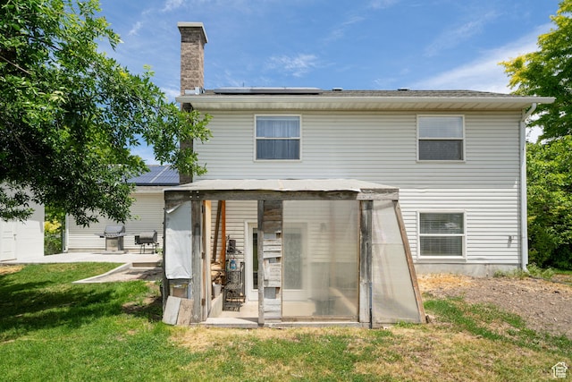 2891 S 600 W, Nibley, UT 84321 - back of property featuring roof mounted solar panels, a chimney, a yard, and a patio