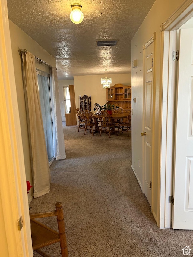2839 S Vanburen Ave E Unit 8, Ogden, UT 84403 - hallway featuring carpet floors, a textured ceiling, and a chandelier