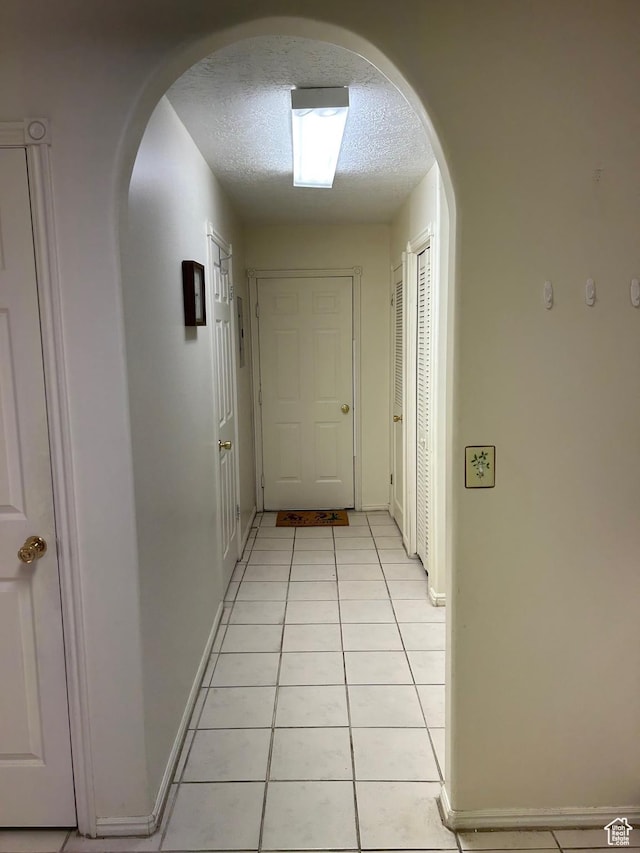 2839 S Vanburen Ave E Unit 8, Ogden, UT 84403 - hallway with arched walkways, a textured ceiling, and light tile patterned flooring