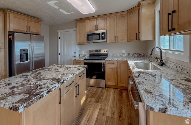 7166 S 4000 E, Price, UT 84501 - kitchen with appliances with stainless steel finishes, light wood-style floors, light stone counters, light brown cabinets, and a center island