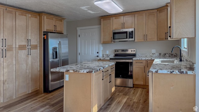 7166 S 4000 E, Price, UT 84501 - kitchen featuring appliances with stainless steel finishes, light wood-type flooring, light brown cabinets, light stone countertops, and a textured ceiling