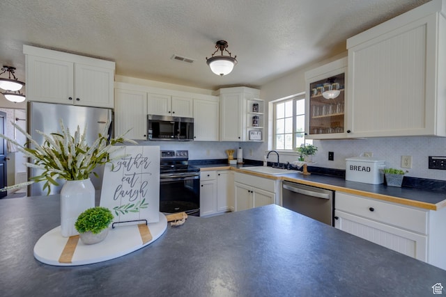 2599 S Foxridge Rd, Garden City, UT 84028 - kitchen with stainless steel appliances, dark countertops, white cabinetry, open shelves, and a textured ceiling