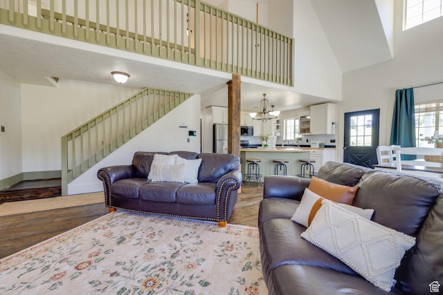 2599 S Foxridge Rd, Garden City, UT 84028 - living room featuring a towering ceiling, light wood-style floors, a chandelier, stairway, and healthy amount of natural light