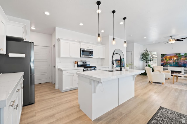 4892 E Lake Corner Dr, Eagle Mountain, UT 84005 - kitchen with stainless steel appliances, ceiling fan, light wood-style flooring, open floor plan, and white cabinets