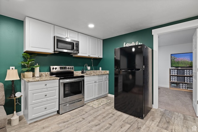 4892 E Lake Corner Dr, Eagle Mountain, UT 84005 - kitchen with appliances with stainless steel finishes, light wood-style flooring, white cabinetry, and light stone counters