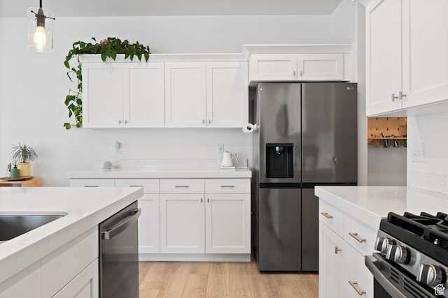 4892 E Lake Corner Dr, Eagle Mountain, UT 84005 - kitchen with stainless steel appliances, white cabinets, light wood-style flooring, hanging light fixtures, and light stone counters