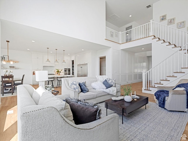 1172 E Candy Ln, American Fork, UT 84003 - living room featuring light wood finished floors, stairs, a high ceiling, and recessed lighting