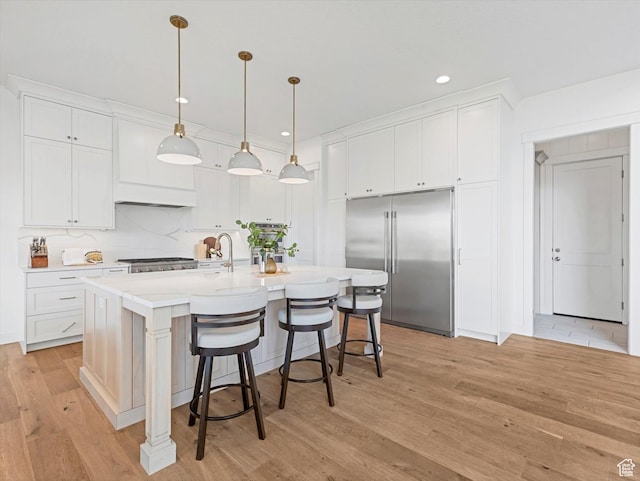 1172 E Candy Ln, American Fork, UT 84003 - kitchen featuring stainless steel built in refrigerator, light wood-style floors, white cabinets, light countertops, and a breakfast bar area
