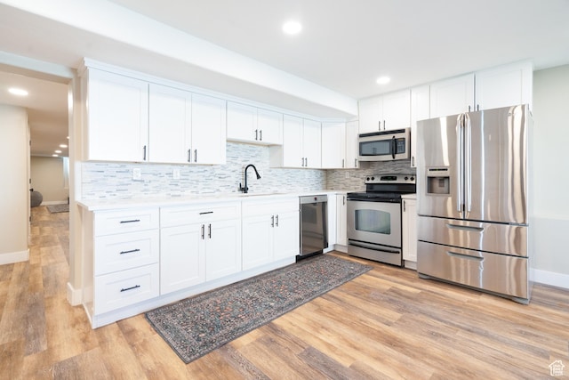 986 View Crest Ln, Kaysville, UT 84037 - kitchen featuring appliances with stainless steel finishes, white cabinets, tasteful backsplash, light wood-style flooring, and recessed lighting