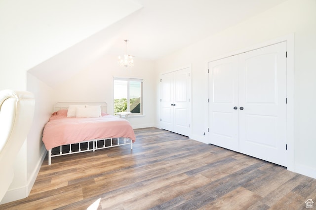 986 View Crest Ln, Kaysville, UT 84037 - bedroom with wood finished floors, a chandelier, multiple closets, and vaulted ceiling