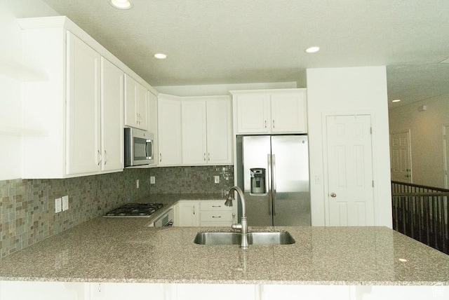 63 N Canyon Maple Rd, Vineyard, UT 84059 - kitchen with stainless steel appliances, a peninsula, light stone countertops, decorative backsplash, and recessed lighting