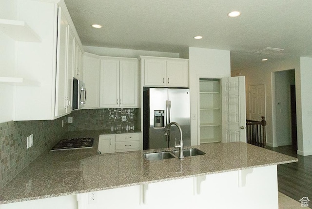 63 N Canyon Maple Rd, Vineyard, UT 84059 - kitchen featuring stainless steel appliances, a peninsula, stone countertops, white cabinets, and backsplash