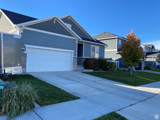 63 N Canyon Maple Rd, Vineyard, UT 84059 - view of front of property featuring a front lawn, concrete driveway, stone siding, and a garage