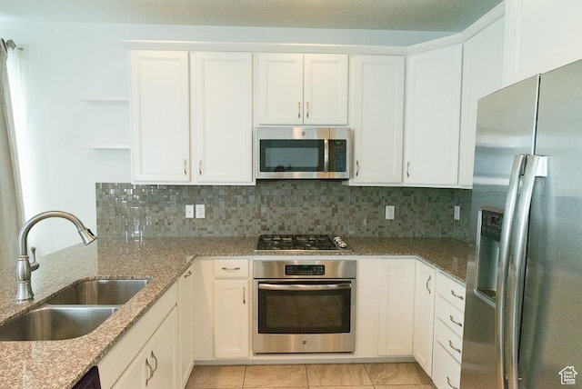 63 N Canyon Maple Rd, Vineyard, UT 84059 - kitchen with appliances with stainless steel finishes, open shelves, white cabinetry, light stone counters, and tasteful backsplash