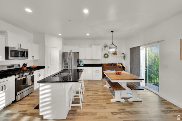 1752 S 570 W, Provo, UT 84601 - kitchen with appliances with stainless steel finishes, dark countertops, light wood-style floors, recessed lighting, and white cabinetry
