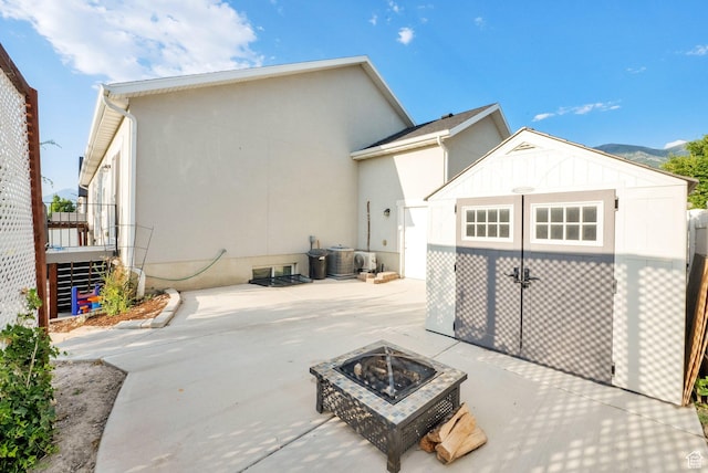 1752 S 570 W, Provo, UT 84601 - rear view of house featuring an outdoor fire pit, a patio, a storage unit, and stucco siding