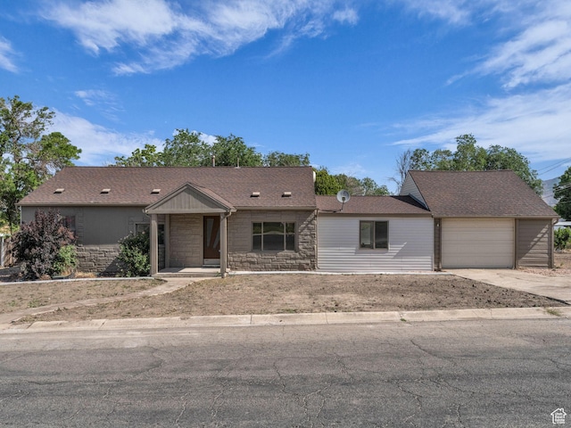 161 E 200 S, Tooele, UT 84074 - view of front of property with stone siding, concrete driveway, and a garage