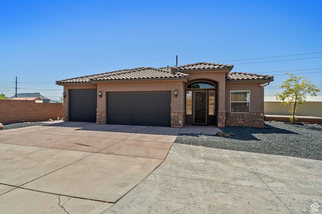 2752 E 50 S, St George, UT 84790 - mediterranean / spanish house with stone siding, stucco siding, concrete driveway, and an attached garage