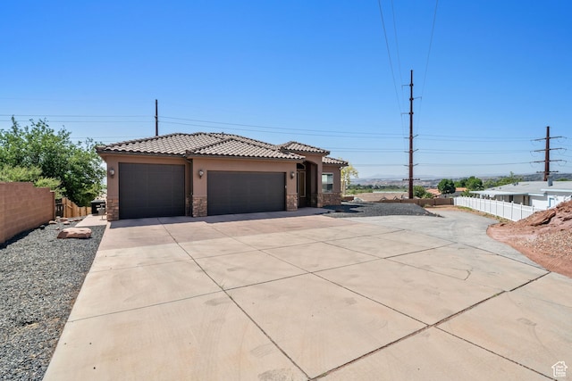 2752 E 50 S, St George, UT 84790 - view of front facade featuring stucco siding, concrete driveway, a garage, stone siding, and a tiled roof