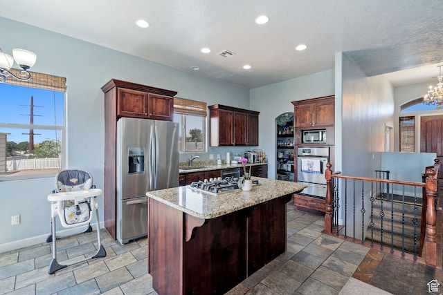 2752 E 50 S, St George, UT 84790 - kitchen featuring stainless steel appliances, a warming drawer, stone tile floors, a chandelier, and a kitchen island