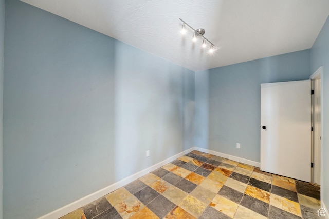 2752 E 50 S, St George, UT 84790 - spare room featuring stone tile floors and rail lighting