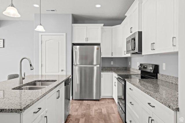 5423 W Black Hills Ln, Herriman, UT 84096 - kitchen with stainless steel appliances, light wood-style floors, white cabinetry, pendant lighting, and recessed lighting