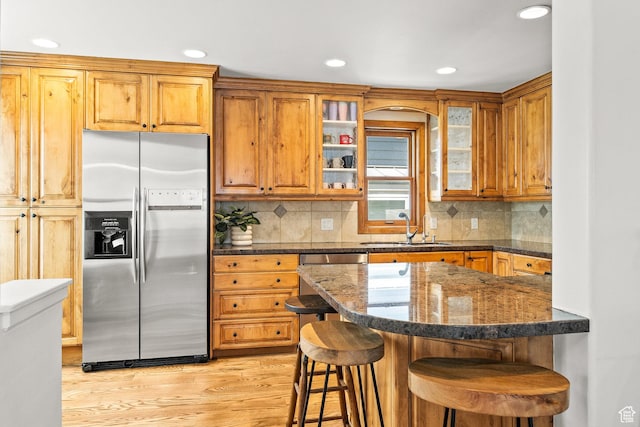 915 Norfolk Ave, Park City, UT 84060 - kitchen with stainless steel appliances, light wood finished floors, a breakfast bar, glass insert cabinets, and recessed lighting