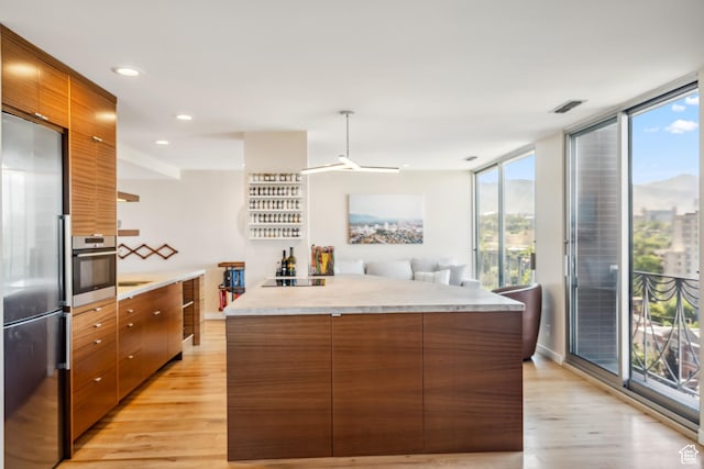 777 E S Temple Unit 13B, Salt Lake City, UT 84102 - kitchen with stainless steel appliances, light wood-type flooring, modern cabinets, brown cabinets, and recessed lighting