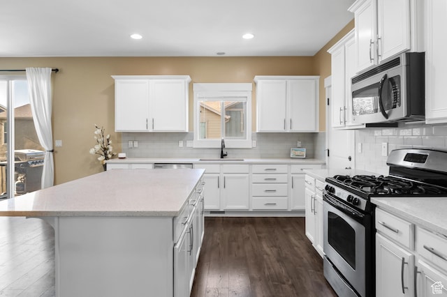5194 Hedgerose Dr, Herriman, UT 84096 - kitchen with appliances with stainless steel finishes, healthy amount of natural light, a kitchen island, dark wood-type flooring, and recessed lighting