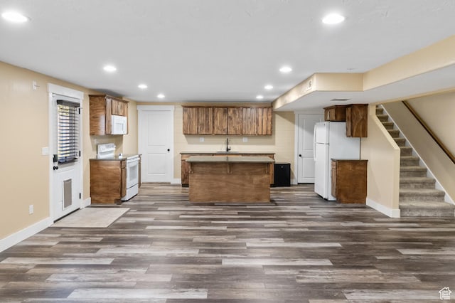 5194 Hedgerose Dr, Herriman, UT 84096 - kitchen with white appliances, recessed lighting, a center island, dark wood finished floors, and brown cabinets