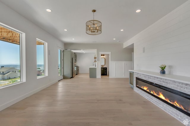 481 E 3675 N, North Ogden, UT 84414 - unfurnished living room featuring a brick fireplace, recessed lighting, a chandelier, and light wood finished floors