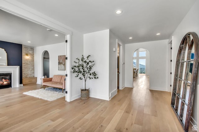 481 E 3675 N, North Ogden, UT 84414 - entryway with arched walkways, light wood-style floors, a glass covered fireplace, and recessed lighting