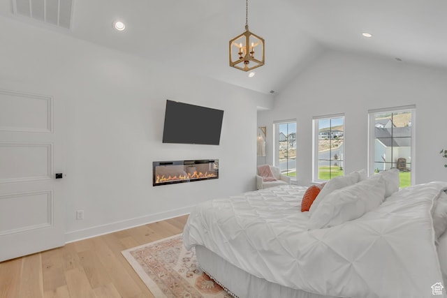 481 E 3675 N, North Ogden, UT 84414 - bedroom with a chandelier, a glass covered fireplace, lofted ceiling, light wood finished floors, and recessed lighting