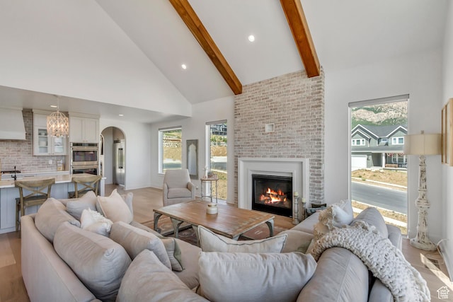 481 E 3675 N, North Ogden, UT 84414 - living room with high vaulted ceiling, arched walkways, a brick fireplace, beam ceiling, and recessed lighting
