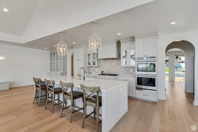 481 E 3675 N, North Ogden, UT 84414 - kitchen with premium range hood, appliances with stainless steel finishes, arched walkways, a chandelier, and backsplash