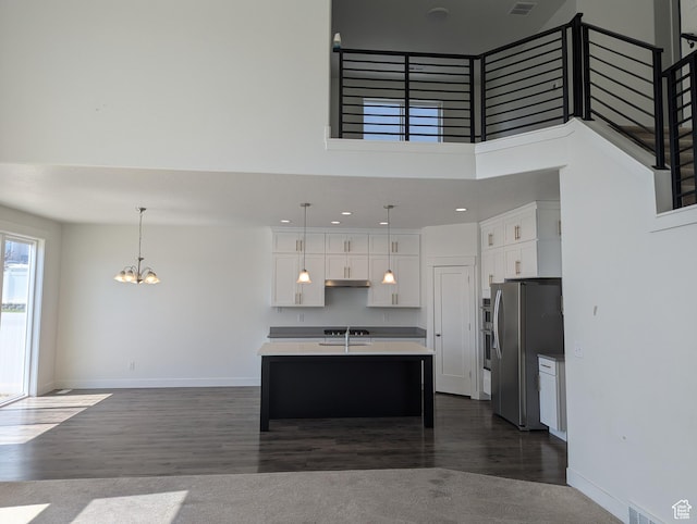 57 N Midland Dr, Saratoga Springs, UT 84045 - kitchen with appliances with stainless steel finishes, a chandelier, white cabinetry, dark wood-style flooring, and a kitchen island with sink