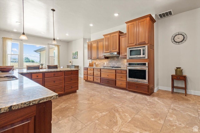 1145 W 500 N, Manti, UT 84642 - kitchen featuring stainless steel appliances, brown cabinetry, tasteful backsplash, under cabinet range hood, and light stone counters