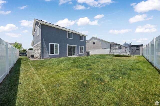 969 S 875 W, Springville, UT 84663 - rear view of house with a trampoline, a fenced backyard, and stucco siding