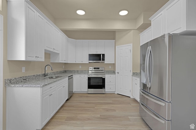 454 E 850 S Unit 106, Brigham City, UT 84302 - kitchen with stainless steel appliances, white cabinets, light stone countertops, light wood-style flooring, and recessed lighting