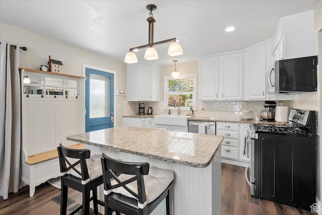 5203 Chambers St, South Ogden, UT 84403 - kitchen featuring appliances with stainless steel finishes, white cabinets, tasteful backsplash, dark wood-style floors, and recessed lighting