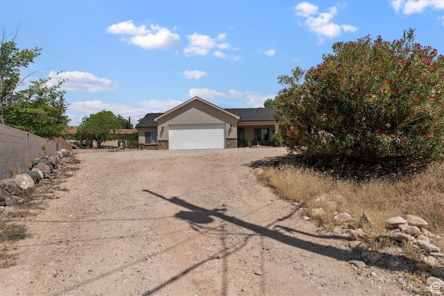 586 N 360 W, La Verkin, UT 84745 - view of front facade featuring dirt driveway, a garage, stucco siding, and stone siding