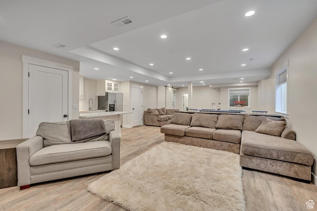2040 E Lambourne Ave, Millcreek, UT 84109 - living room with light wood-type flooring, recessed lighting, and a raised ceiling