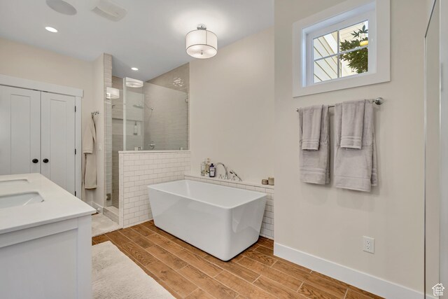2040 E Lambourne Ave, Millcreek, UT 84109 - full bath featuring a shower stall, a freestanding tub, wood finish floors, double vanity, and recessed lighting