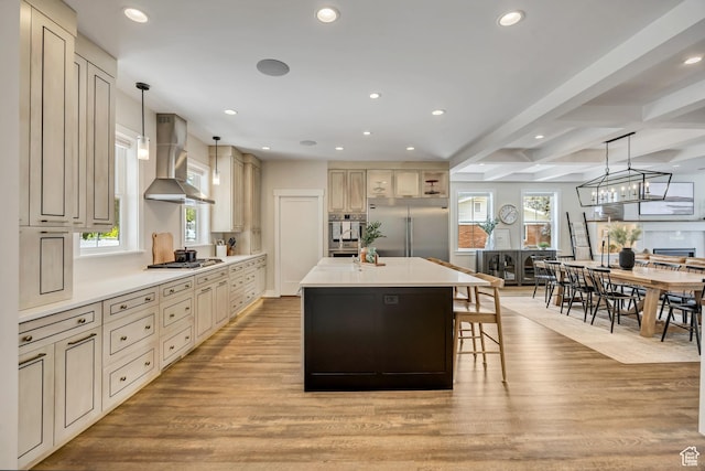 2040 E Lambourne Ave, Millcreek, UT 84109 - kitchen with wall chimney range hood, appliances with stainless steel finishes, light wood finished floors, cream cabinets, and recessed lighting