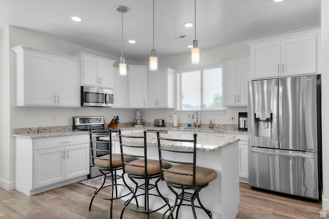 231 N 750 W, Springville, UT 84663 - kitchen with appliances with stainless steel finishes, white cabinetry, a breakfast bar area, light wood-style floors, and recessed lighting