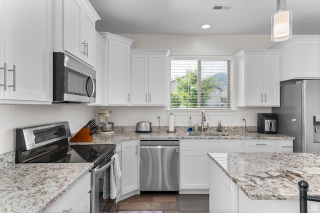 231 N 750 W, Springville, UT 84663 - kitchen featuring stainless steel appliances, white cabinetry, light stone countertops, dark wood-style flooring, and hanging light fixtures