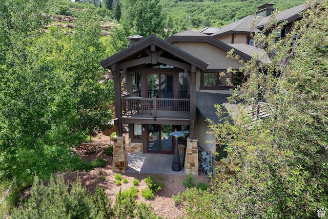 4121 Fairway Ln Unit A1, Park City, UT 84098 - view of front of property with stucco siding, a patio, a view of trees, and a shingled roof